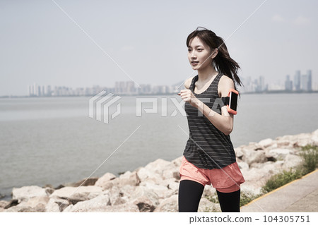young asian woman running jogging outdoors by the sea 104305751