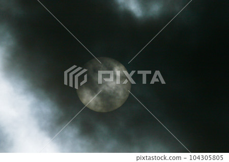 Sun disk behind backlit clouds Sun disk behind backlit clouds 104305805