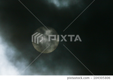 Sun disk behind backlit clouds Sun disk behind backlit clouds 104305806