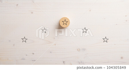 Five stars positioned in a pyramid shape with the top one drawn on wooden cut circle 104305849