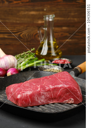 Closeup view of uncooked beef steak boneless on grill pan Closeup view of uncooked beef steak boneless on grill pan 104306531