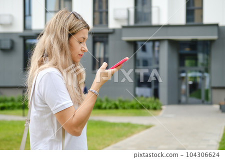 Woman listening to voice message on smartphone Woman listening to voice message on smartphone 104306624