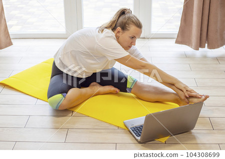 Beautiful young woman in sportswear doing sport exercises on yoga mat at home. Beautiful young woman in sportswear doing sport exercises on yoga mat at home. 104308699