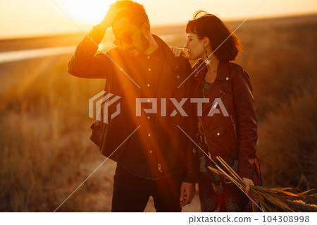 Enjoying time together. Stylish and loving couple enjoying each other by the sea. 104308998