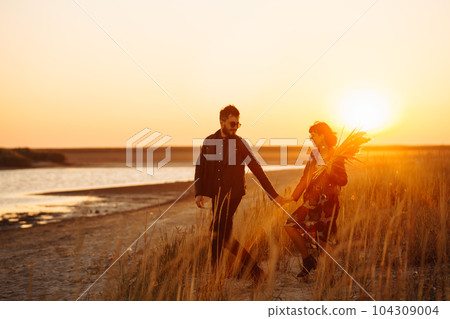Enjoying time together. Stylish and loving couple enjoying each other by the sea. 104309004