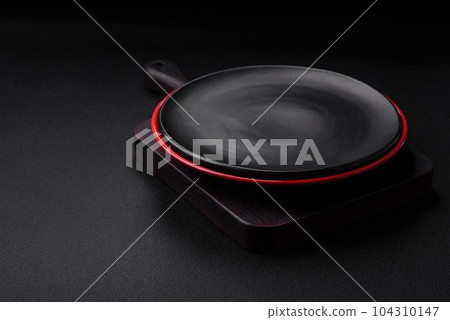 Empty ceramic plate on dark textured concrete background 104310147