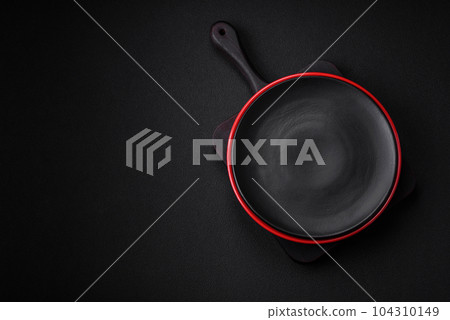 Empty ceramic plate on dark textured concrete background 104310149