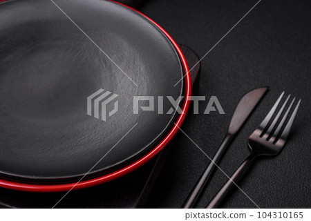 Empty ceramic plate on dark textured concrete background 104310165