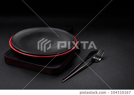 Empty ceramic plate on dark textured concrete background Empty ceramic plate on dark textured concrete background 104310167