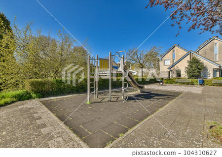 a playground in the middle of a residential area with lots of trees and bushes on either side of the street a playground in the middle of a residential area with lots of trees and bushes on either side of the street 104310627