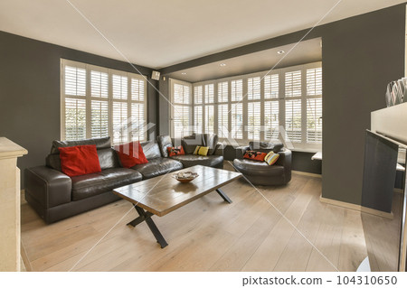 a living room with couches, coffee table, and tv in the center of the room is dark grey 104310650