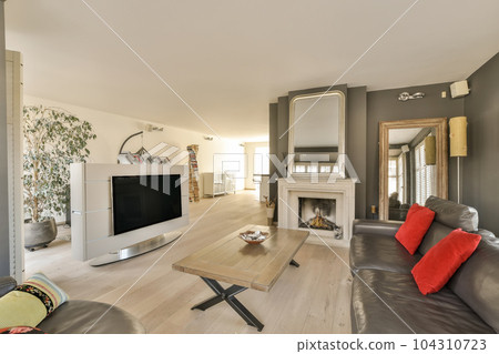 a living room with couches and a tv on the wall in front of the fireplace, there is a large mirror hanging above 104310723