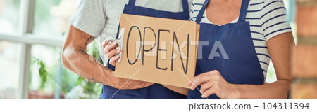 Middle aged caucasian owners of shop with open board Middle aged caucasian owners of shop with open board 104311394