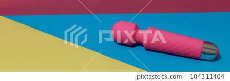 Pink dildo vibrator for satisfaction on colored background with shadows. Sex toy for adult 104311404