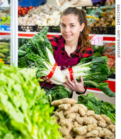 Smiling american woman shopping assistant holding lettuce Smiling american woman shopping assistant holding lettuce 104313499