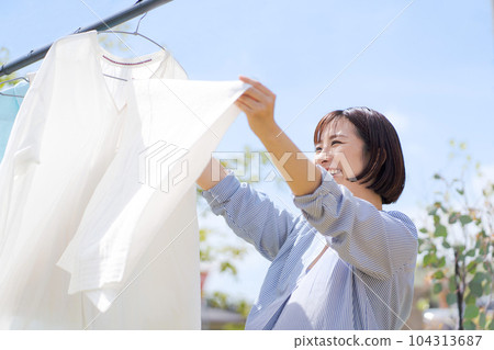 Photo of a woman doing laundry Photo of a woman doing laundry 104313687