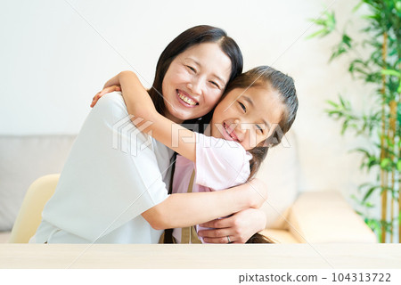 Parent and child hugging with a smile 104313722
