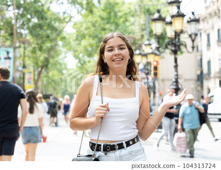 Happy young female tourist strolling along La Rambla in Barcelona 104313724