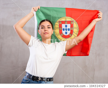 Attractive female football fan holding Portugal flag 104314327