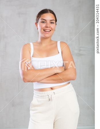 Portrait of young cute cheerful girl smiling looking at camera over grey background 104314431