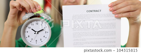 Businesswoman holding contract agreement and alarm clock Businesswoman holding contract agreement and alarm clock 104315815