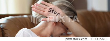 Woman showing palm with stop lettering, protesting against domestic violence 104315819