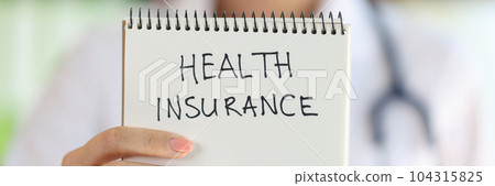 Female hand holding notepad with health insurance lettering Female hand holding notepad with health insurance lettering 104315825