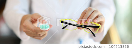Woman doctor holding glasses and contact lens case 104315826