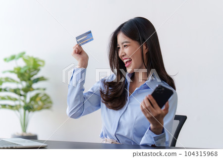 Young woman holding credit card and enjoy with shopping on ecommerce application 104315968