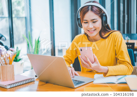 young student wearing headphones studies online, distance learning, and keeps up to date on the global coronavirus pandemic. 104316198