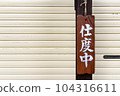 A wooden billboard under preparation hung in front of the storefront shutter 104316611