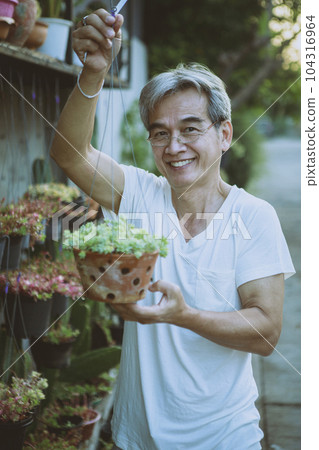 asian holding hanging houseplant pot toothy smiling with happiness face standing outdoor asian holding hanging houseplant pot toothy smiling with happiness face standing outdoor 104316964