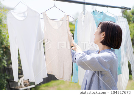 Portrait of a woman doing laundry Portrait of a woman doing laundry 104317673