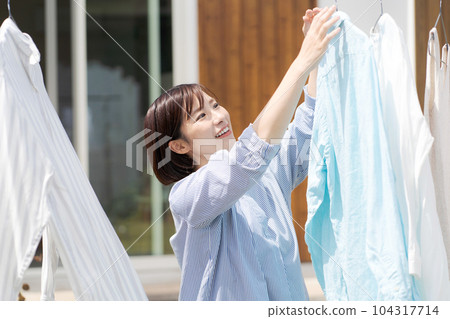 Portrait of a woman doing laundry Portrait of a woman doing laundry 104317714
