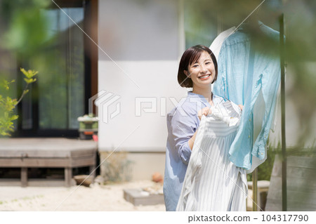 Portrait of a woman doing laundry Portrait of a woman doing laundry 104317790