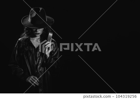 woman in a leather raincoat and hat with a whip flogger for BDSM woman in a leather raincoat and hat with a whip flogger for BDSM 104319256