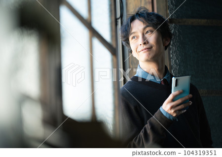 A man in his 30s with a smartphone 104319351