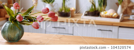 Banner vase with pink tulips in a modern kitchen. 104320574