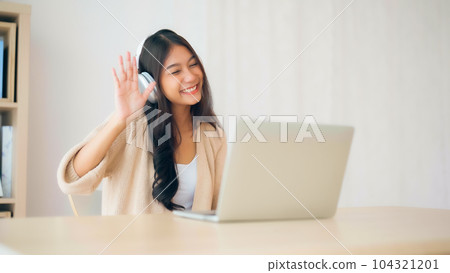 Young Asian Woman Engaged in Productive Remote Work and Online Learning Young Asian Woman Engaged in Productive Remote Work and Online Learning 104321201