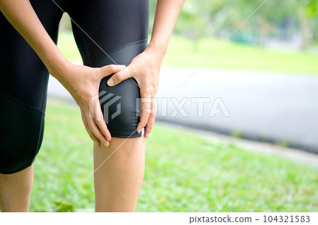 Woman knee pain from jogging She used her hands to massage her knees to relieve her pain. Woman knee pain from jogging She used her hands to massage her knees to relieve her pain. 104321583