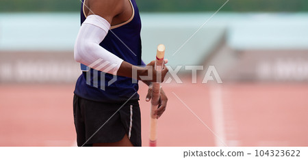 Pole vaulter prepares for jump, looking from behind 104323622