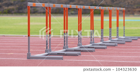 Eight track hurdles on a track in each lane 104323630