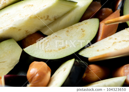 A cooking scene where eggplant and wiener sausage are fried in a frying pan. A cooking scene where eggplant and wiener sausage are fried in a frying pan. 104323650