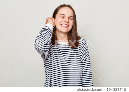 Happy face. Positive emotions. Smiling attractive cheerful brown haired woman wearing striped shirt posing isolated over gray background Happy face. Positive emotions. Smiling attractive cheerful brown haired woman wearing striped shirt posing isolated over gray background 104323740