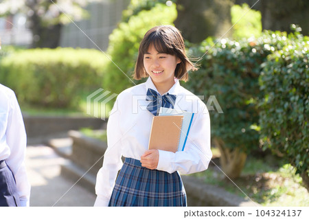 A smiling junior high school girl walking in the schoolyard A smiling junior high school girl walking in the schoolyard 104324137
