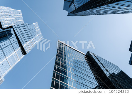 Business skyscrapers and office business center building architecture in perspective on blue sky. Economy, exchange, finance concept. Business skyscrapers and office business center building architecture in perspective on blue sky. Economy, exchange, finance concept. 104324223