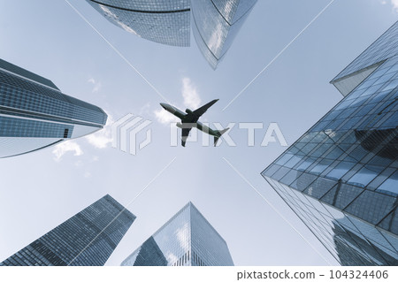 Airplane flying on business skyscrapers of financial center. Travel, economy, cargo, transportation concept 104324406