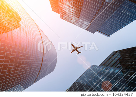 Airplane flying on business skyscrapers of financial center. Travel, economy, cargo, transportation concept Airplane flying on business skyscrapers of financial center. Travel, economy, cargo, transportation concept 104324437