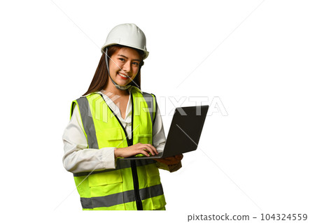 Smiling civil engineer woman wearing helmet and vest holding laptop isolated white background 104324559