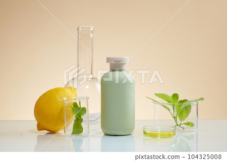 Unlabeled bottle in pastel color arranged with some laboratory glassware. Container packaging of skin care branding mockup extracted from Lemon (Citrus limon) 104325008